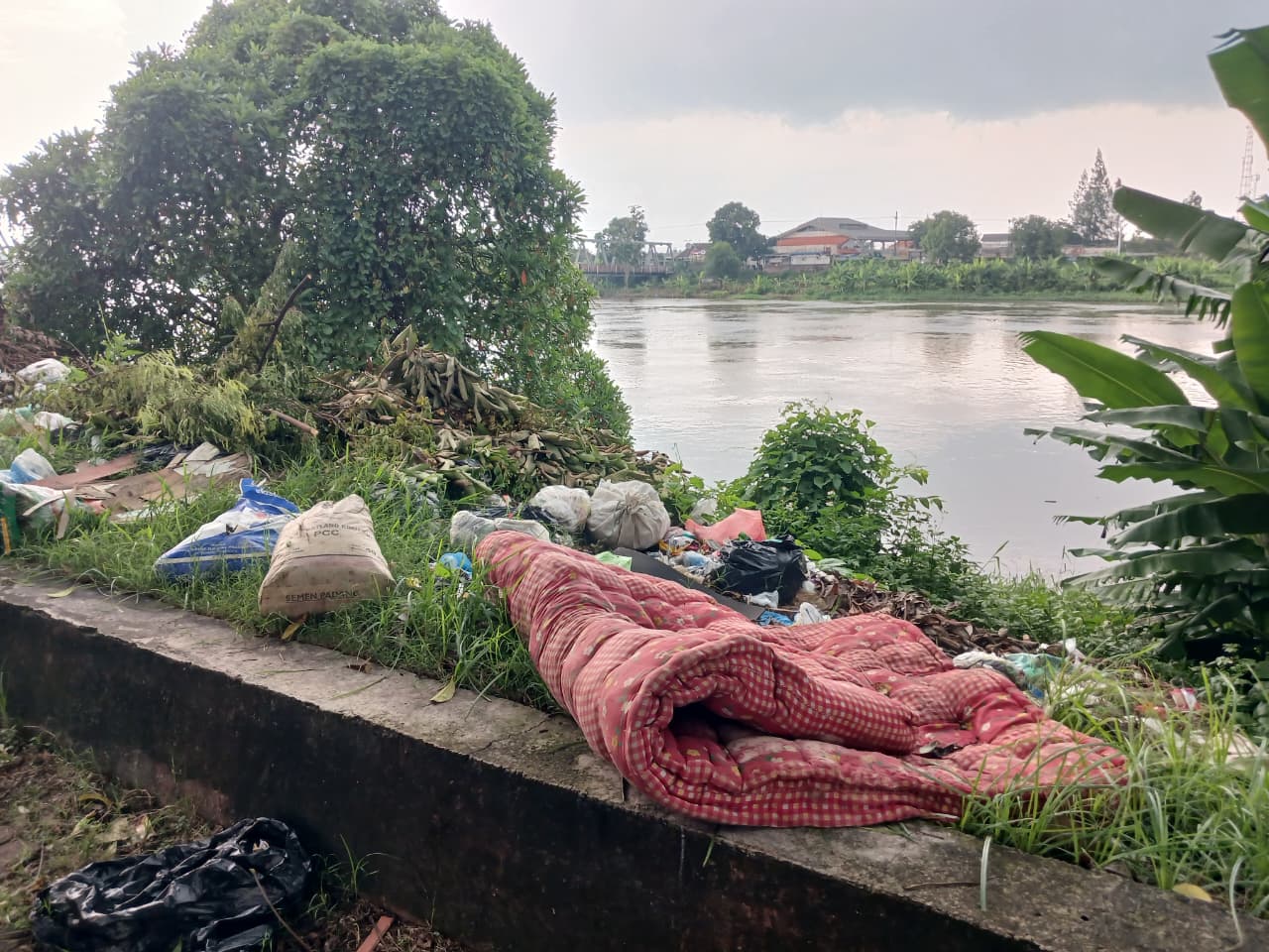 MENUMPUK: Sampah liar sisa rumah tangga hingga kasur bekas dibuang di tanggul Sungai Brantas, Jalan Hayam Wuruk, Kota Mojokerto, kemarin (11/2).