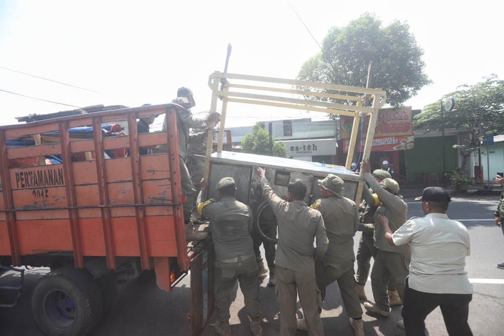 DISITA: Anggota Satpol PP Kota Mojokerto mengangkuti rombong PKL yang terkena razia di Jalan Raya Surodinawan, Kamis (12/2).