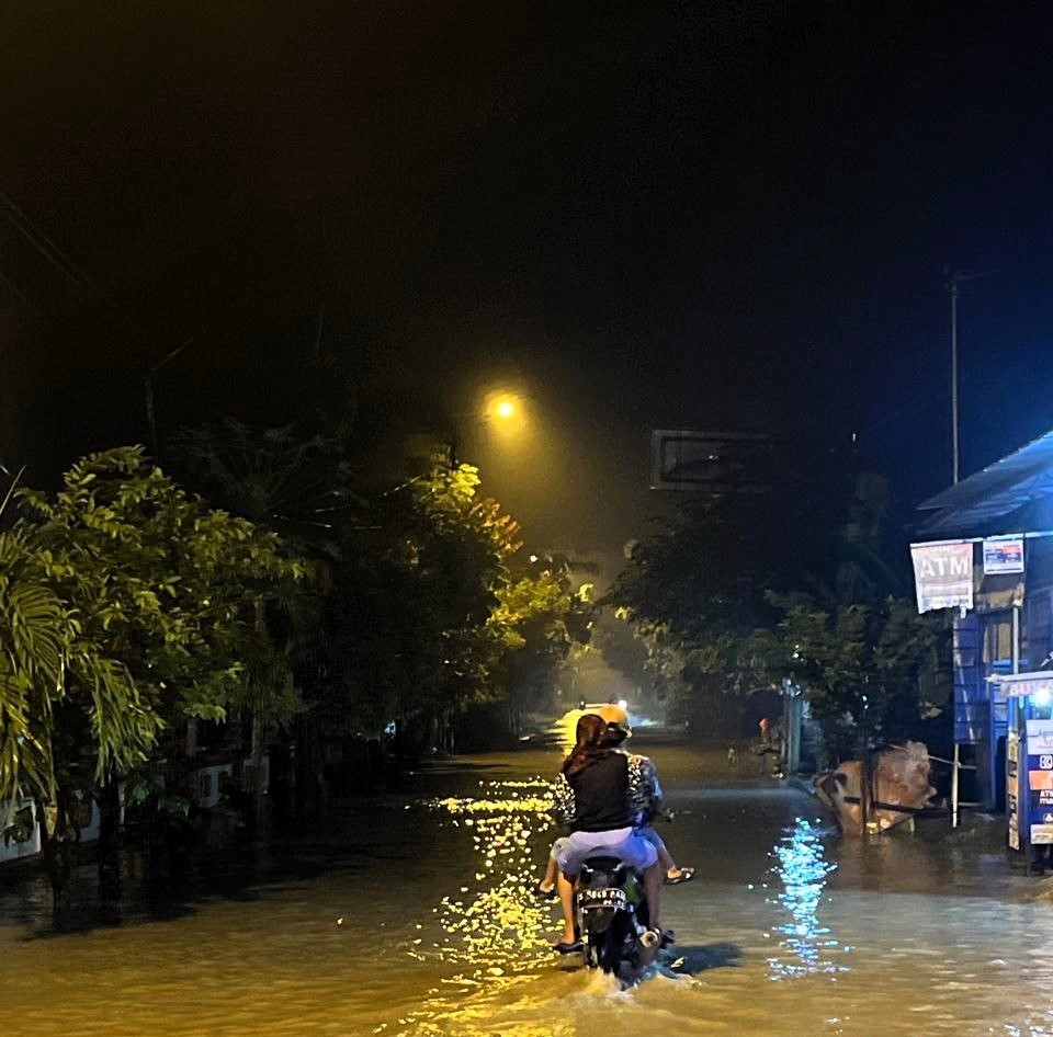TERGENANG: Pemotor nekat menerjang banjir yang menggenangi Jalan Desa Pandankrajan, Kecamatan Kemlagi, Kabupaten Mojokerto, Rabu (12/2) malam.