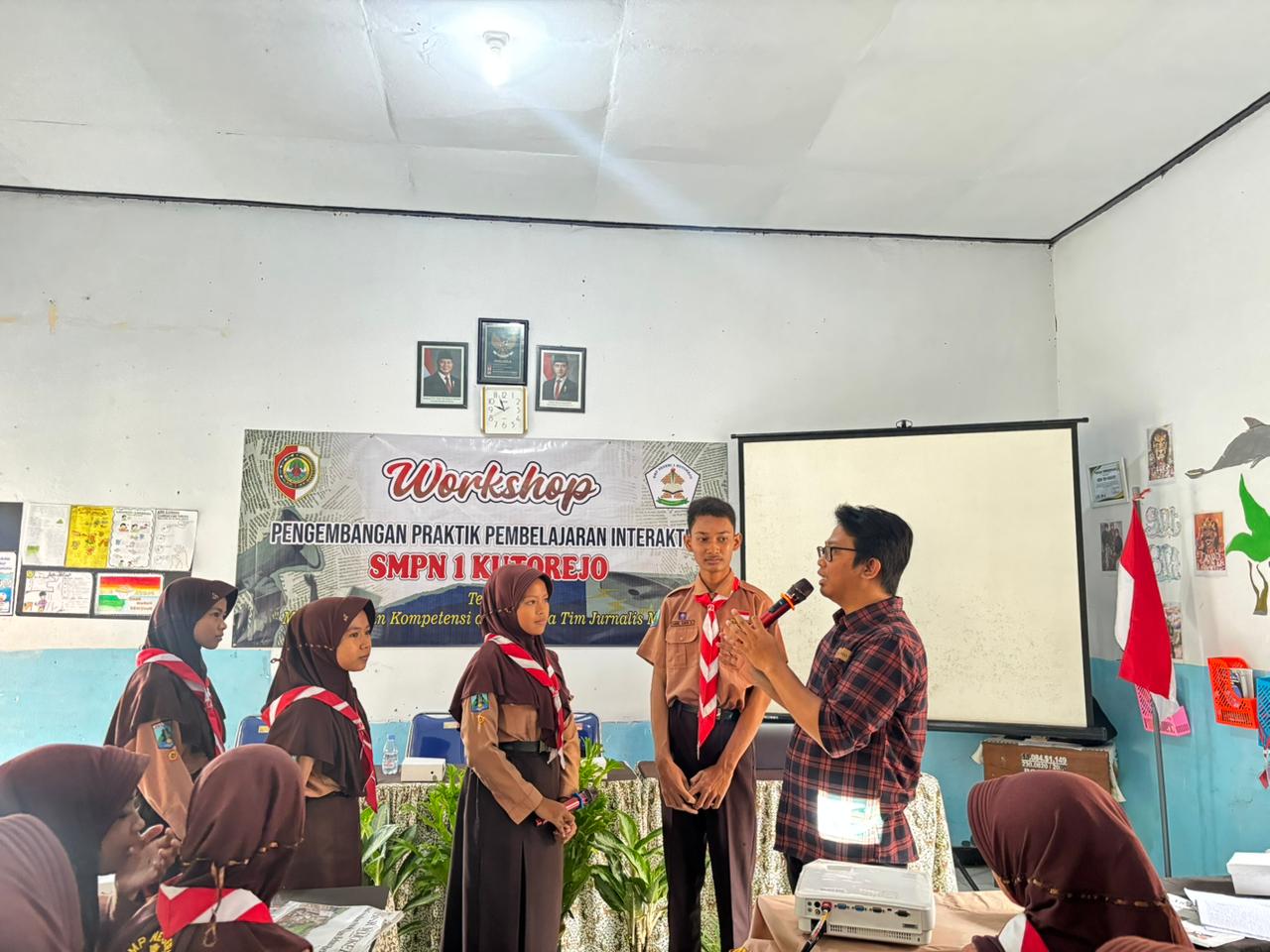 ANTUSIASME: Redaktur Jawa Pos Radar Mojokerto Fendy Hermansyah mengajari siswa SMPN 1 Kutorejo teknik wawancara, Jumat (13/2).