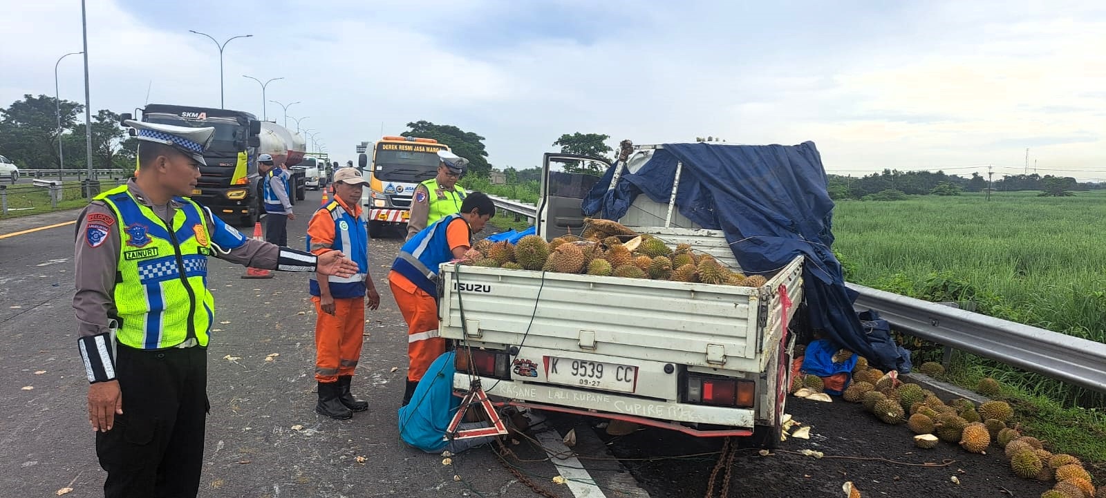 CELAKA: Petugas menangani pikap muatan durian yang mengalami kecelakaan tunggal di Tol Sumo KM 713+200, kemarin (16/2) pagi.