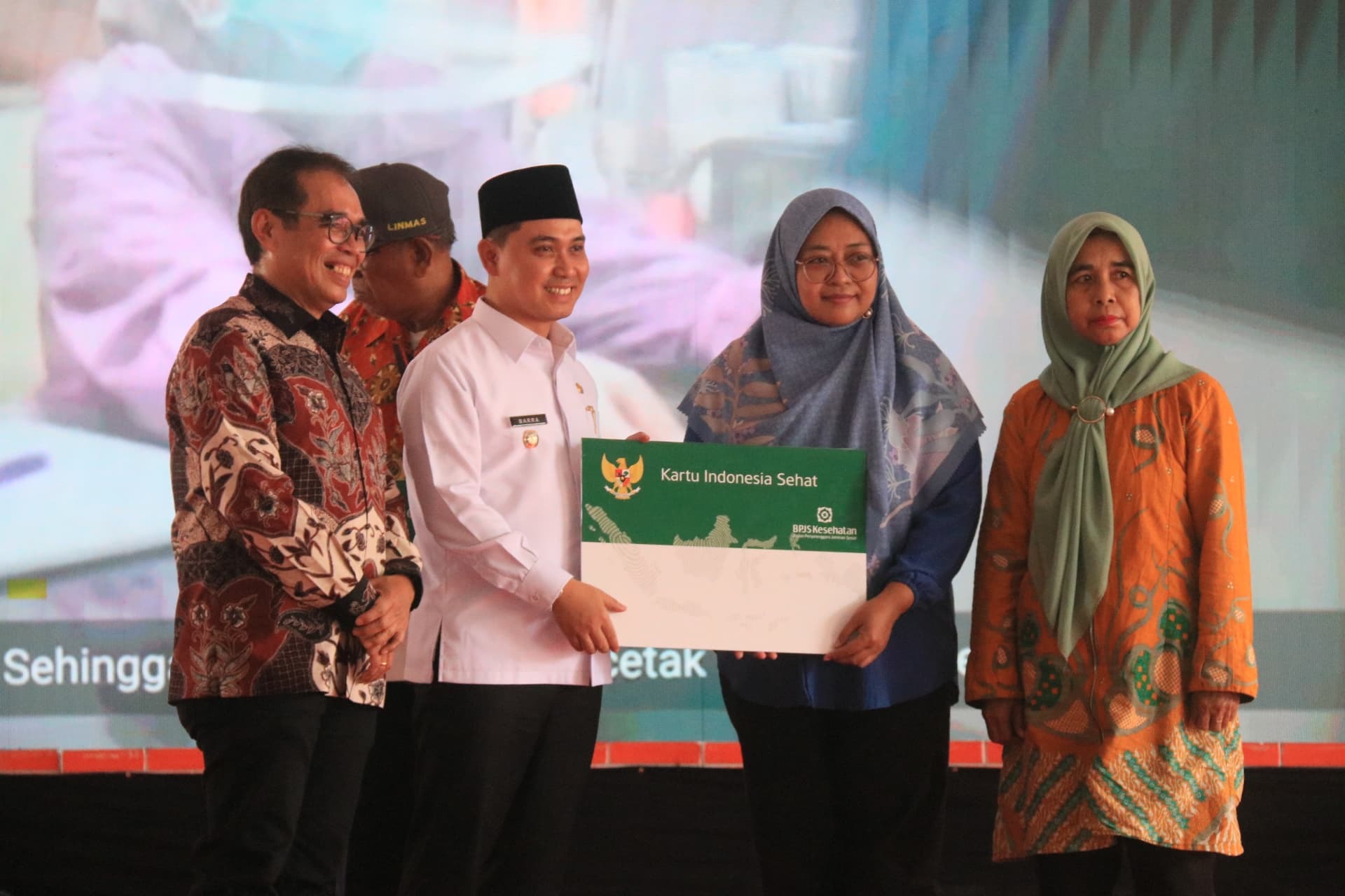 PROGRAM UNGGULAN: Bupati Muhammad Albarraa menyerahkan secara simbolis penerima manfaat program unggulan UHC Prioritas, di Pendapa Graha Majatama, Pemkab Mojokerto.