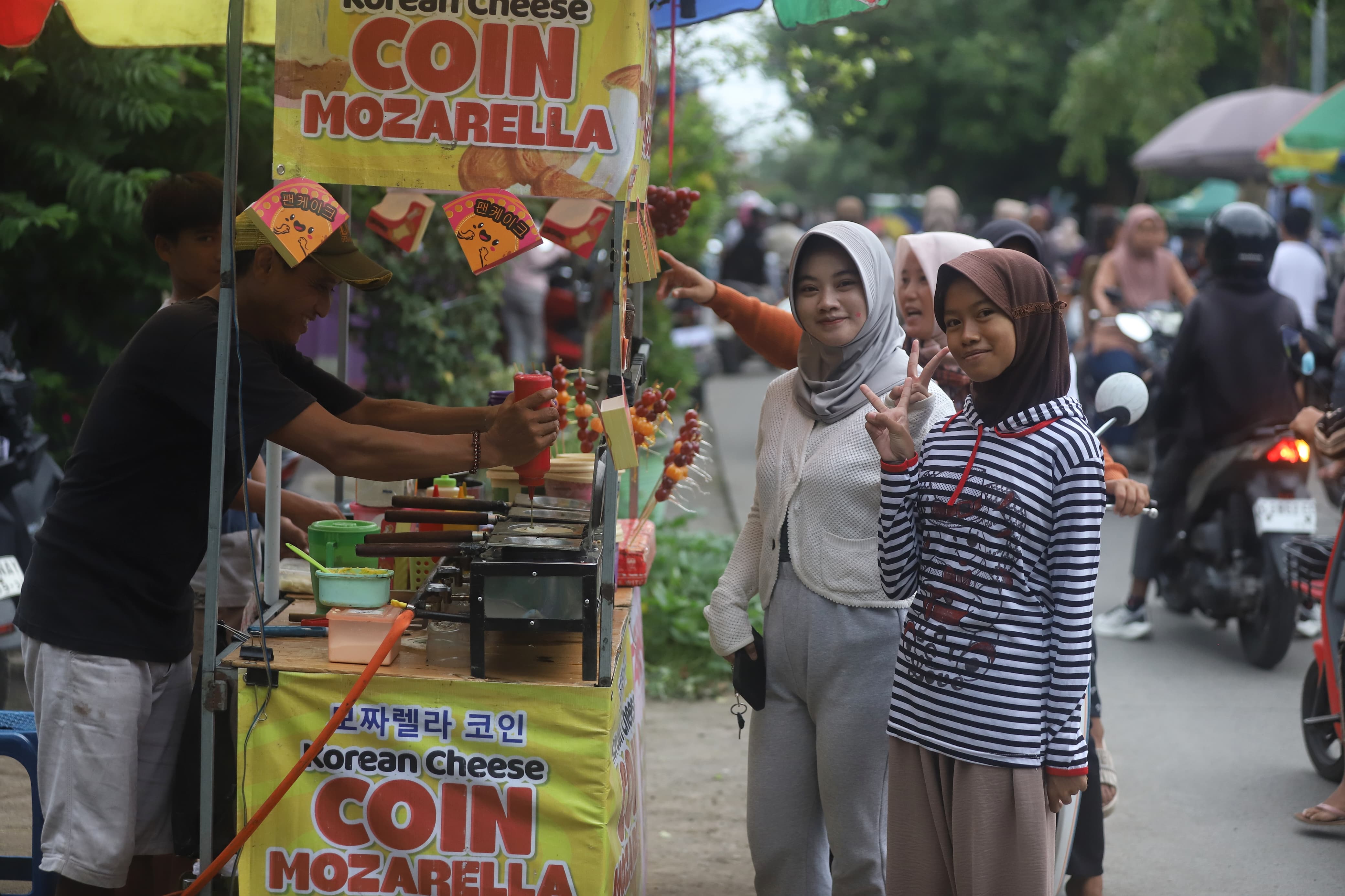 DISUKAI ANAK MUDA: Sejumlah anak muda Desa Randegan, Kecamatan Dawarblandong, Kabupaten Mojokerto berpose di depan stan penjual makanan Korea Desa Randegan, Kecamatan Dawarblandong, Sabtu (21/2). 