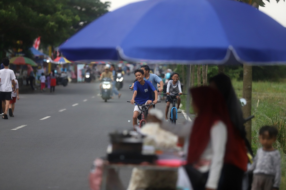 CERIA: Sejumlah anak tengah bersepeda melintasi kawasan pedagang musiman yang menjual aneka sajian takjil di Jalan Surodinawan Baru, Kota Mojokerto, Jumat (20/2).  