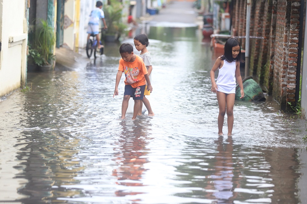 BANJIR KOTA: Sejumlab bocah bermain air di tengah genangan yang muncul di kampung Blooto, Kecamatan Prajurit Kulon, Kota Mojokerto, Minggu (22/2).