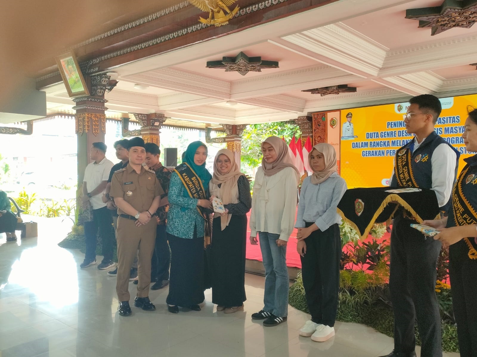 KOLABORATIF: Bupati Mojokerto Muhammad Albarraa didampingi Bunda Genre Kabupaten Mojokerto Shofiya Hanak Albarraa menyerahkan cenderamata kepada Duta Genre Desa di Pendapa Graha Majatama, Pemkab Mojok
