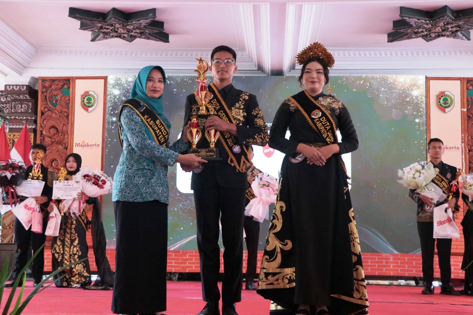 LANGKAH EDUKATIF: Bunda Genre Kabupaten Mojokerto Shofiya Hanak Albarraa menyerahkan piala kepada Duta Genre Berencana tingkat kabupaten di Pendapa Graha Majatama, Pemkab Mojokerto.  