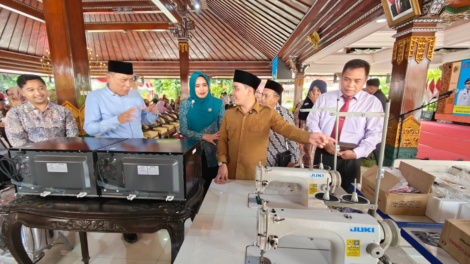 SUPPORT: Bupati Mojokerto Muhammad Albarraa didampingi Kepala Diskop UM Abdulloh Muchtar saat menyerahkan bantuan peralatan kepada para pelaku usaha mikro Desember 2025.