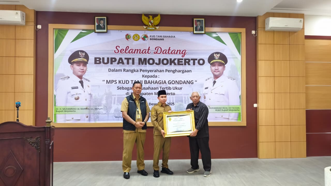 APRESIASI: Bupati Mojokertto Muhammad Albarraa didampingi Kepala Disperindag Noerhono menyerahkan penghargaan kepada MPS KUD Tani Bahagia Gondang sebagai perusahaan tertib ukur.