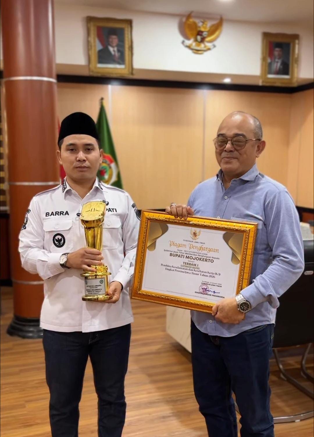 PRESTASI: Bupati Mojokerto Muhammad Albarraa didampingi Kepala Disnaker Kabupaten Mojokerto Yo&rsquo;ie Afrida Soesetyo Djati menunjukkan piala dan sertifikat penghargaan Pembina Terbaik I K3 tingkat Jatim.