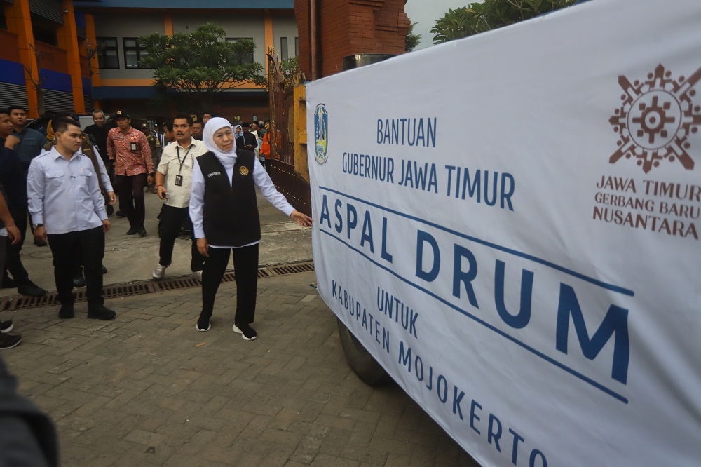 SUPLAI MATERIAL: Gubernur Jatim Khofifah Indar Parawansa menyalurkan langsung bantuan 400 drum aspal untuk Pemkab Mojokerto di kompleks SPAM Mojolagres, Desa Sidoharjo, Kecamatan Gedeg, Kamis (26/2). 