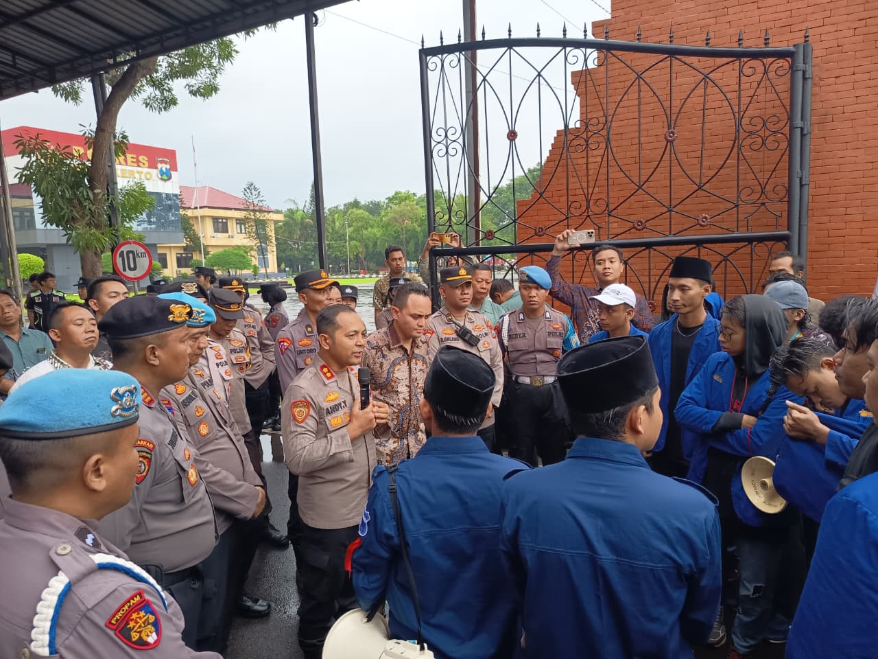 TANGGAPI TUNTUTAN: Kapolres Mojokerto AKBP Andi Yudha Pranata saat menemui massa aksi dari PC PMII Mojokerto di pintu gerbang Mapolres Mojokerto, kemarin (27/2). 