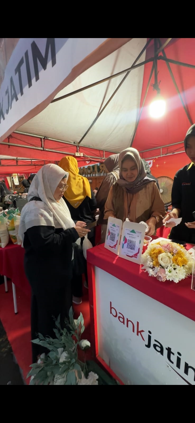 TEBUS: Salah seorang pengunjung bazar Ramadan melakukan transaksi tebus murah sembako di tenda Bank Jatim Cabang Mojokerto.  