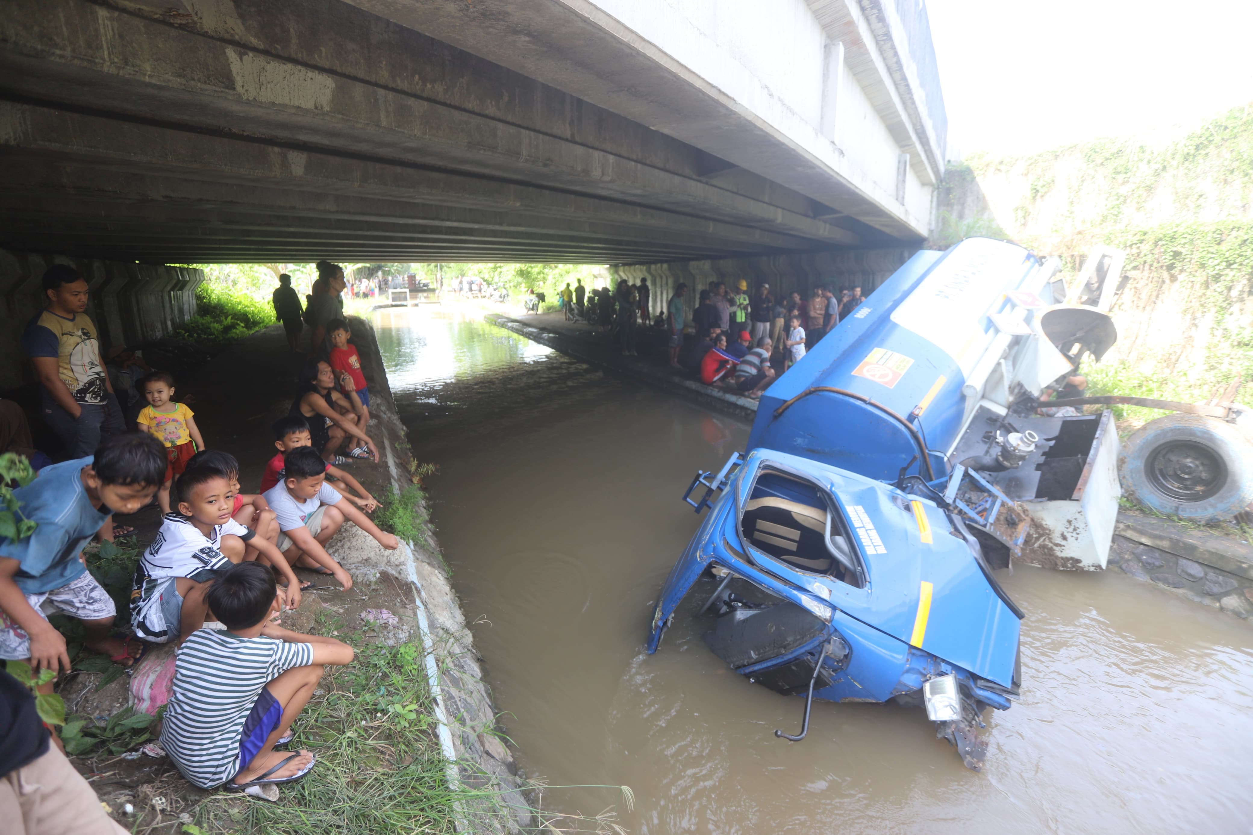 NAHAS: Warga menyemut di lokasi jatuhnya truk dari tol Mojokerto area Desa Kemantren, Kecamatan Gedeg, Kabupaten Mojokerto, Minggu (1/3). 