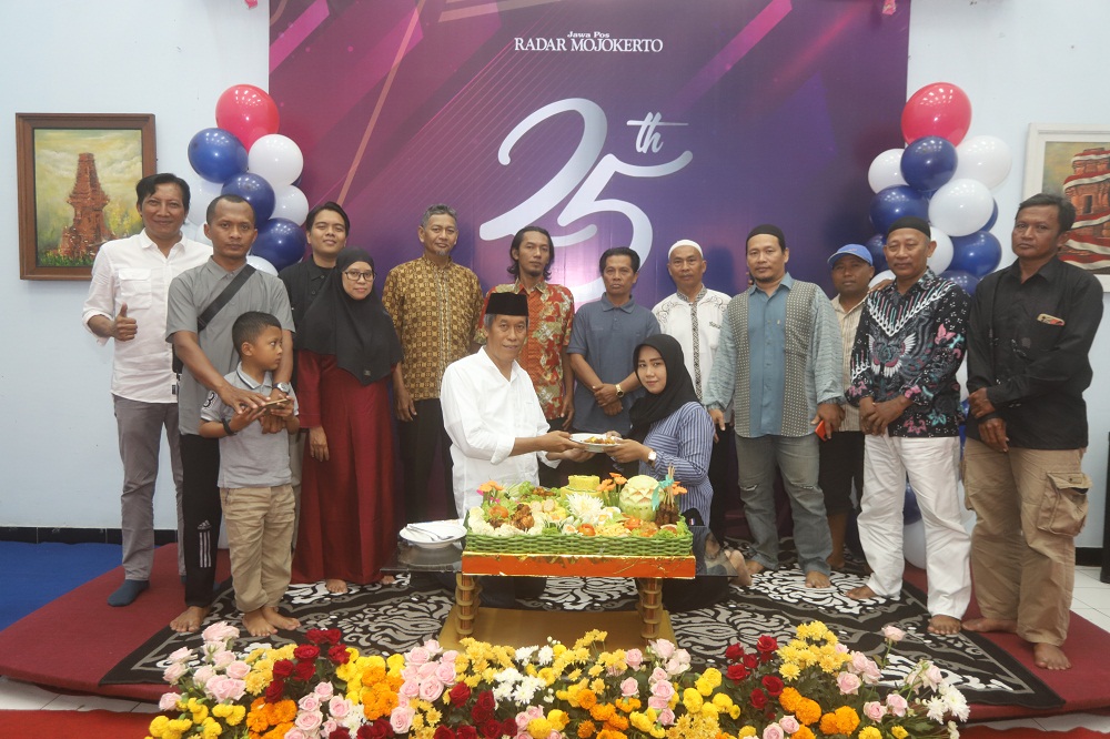SETIA: Direktur Jawa Pos Radar Mojokerto M. Nur Kholis menyerahkan potongan tumpeng kepada perwakilan agen koran dalam acara tasyakuran HUT ke-25 di aula kantor JPRM, kemarin (1/3).  