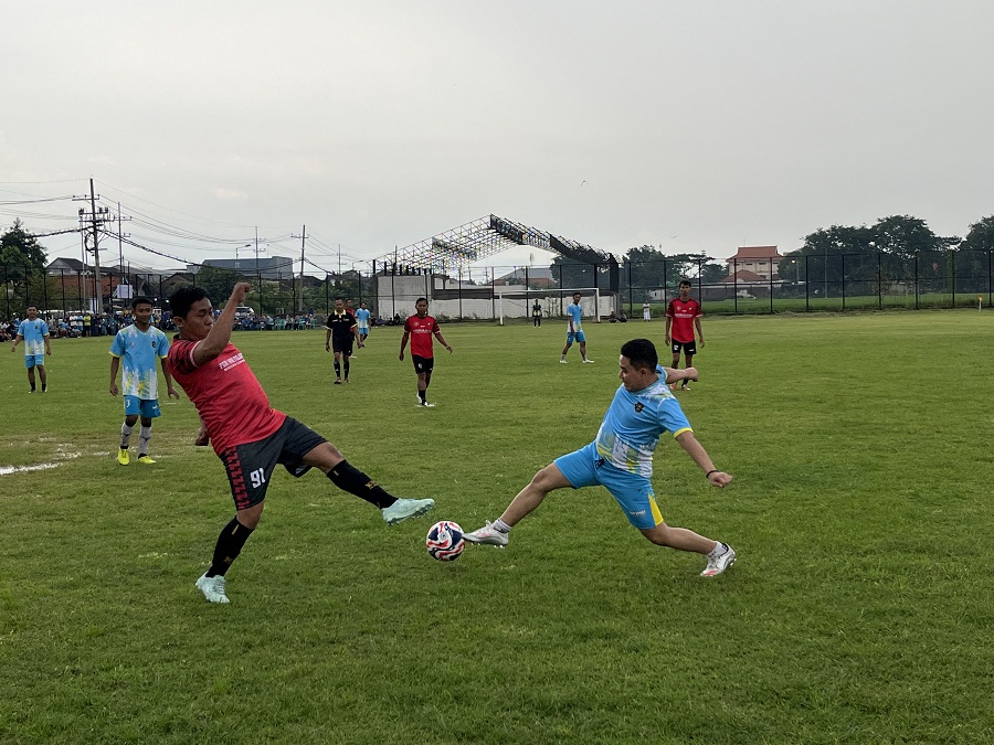 MENANG TELAK: Bupati Mojokerto Muhammad Albarraa berjibaku berebut bola dengan pemain PGRI Kabupaten Mojokerto saat uji coba di Lapangan Desa Gayaman, Kecamatan Mojoanyar, Sabtu (28/2).  