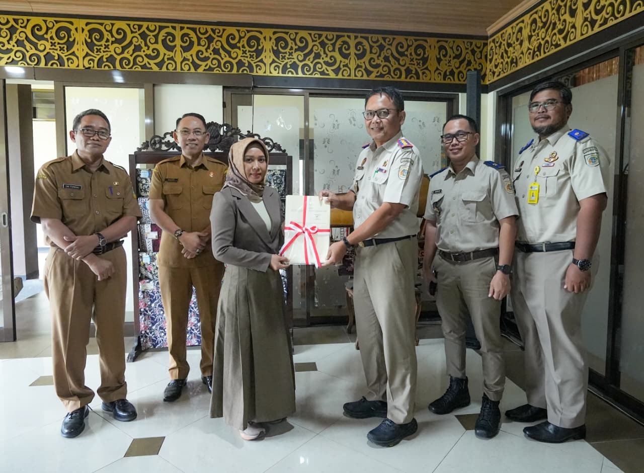 SIMBOLIS: Kepala BPN Kota Mojokerto Solehudin menyerahkan sertifikat hak pakai aset tanah pemkot kepada Wali Kota Ika Puspitasari di Rumah Rakyat, Senin (2/3).  