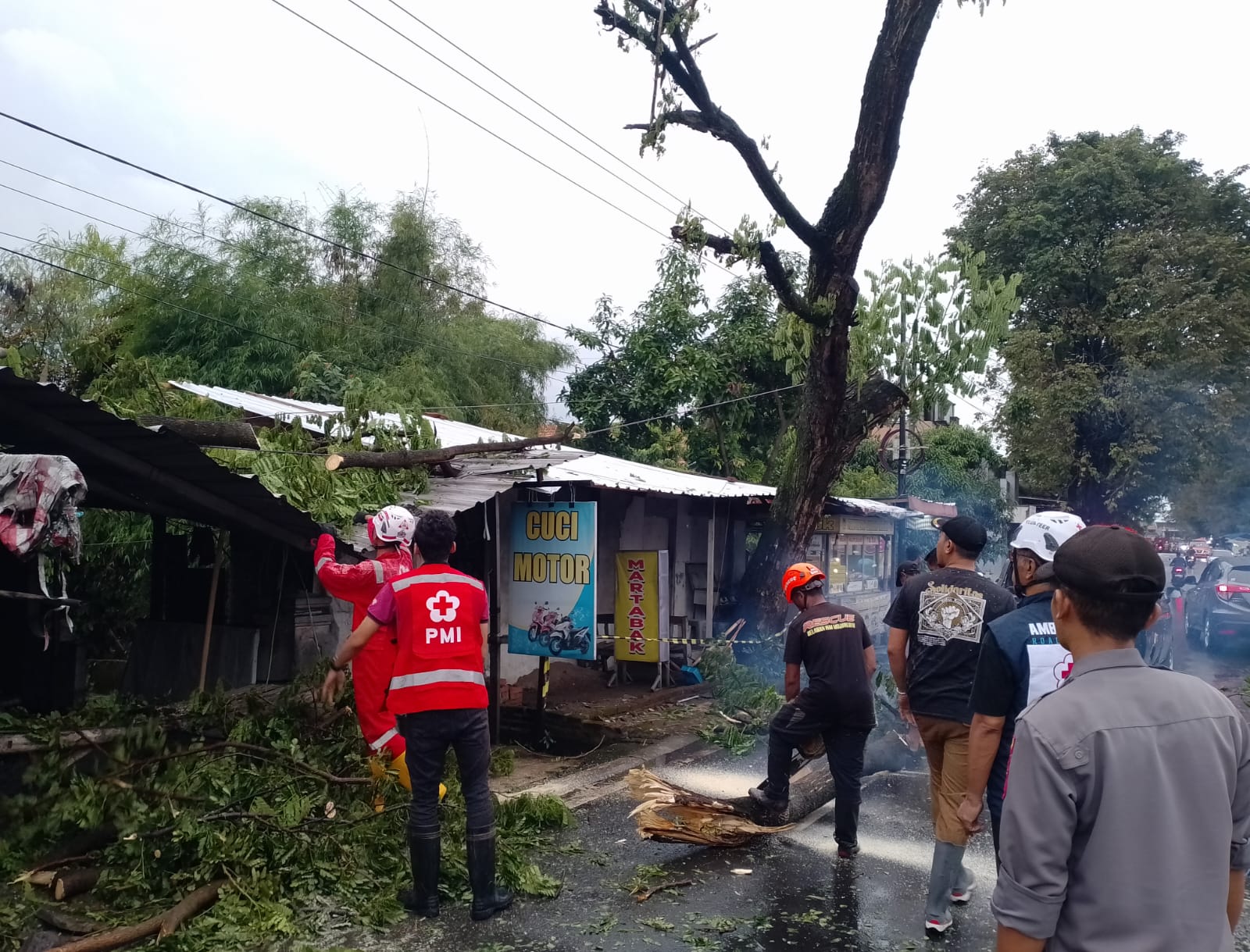 TERDAMPAK: Petugas BPBD Kabupaten Mojokerto bersama tim gabungan melakukan penanganan dahan pohon yang patah dan menimpa atap tempat usaha di Desa/Kecamatan Dlanggu, Selasa (3/3).  