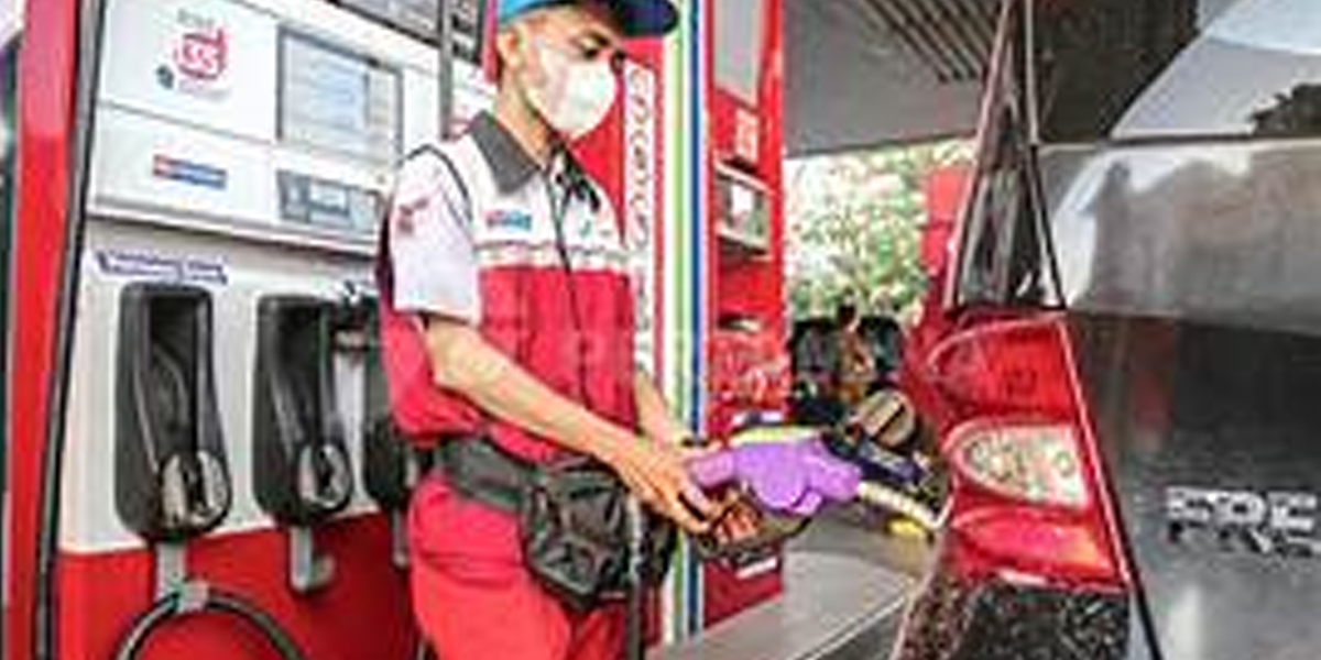 Petugas SPBU melayani pengisian bensin ke kendaraan pelanggan. Pemerintah memastikan pasokan BBM nasional tetap aman