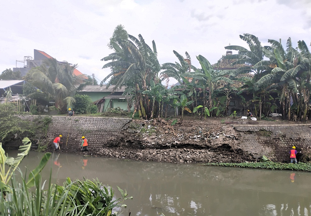 DIPERBAIKI: Pekerja proyek memperbaiki tanggul selatan aliran Sungai Sadar di Lingkungan Tropodo, Kelurahan Meri, Kecamatan Kranggan, Kota Mojokerto, Selasa (3/3).