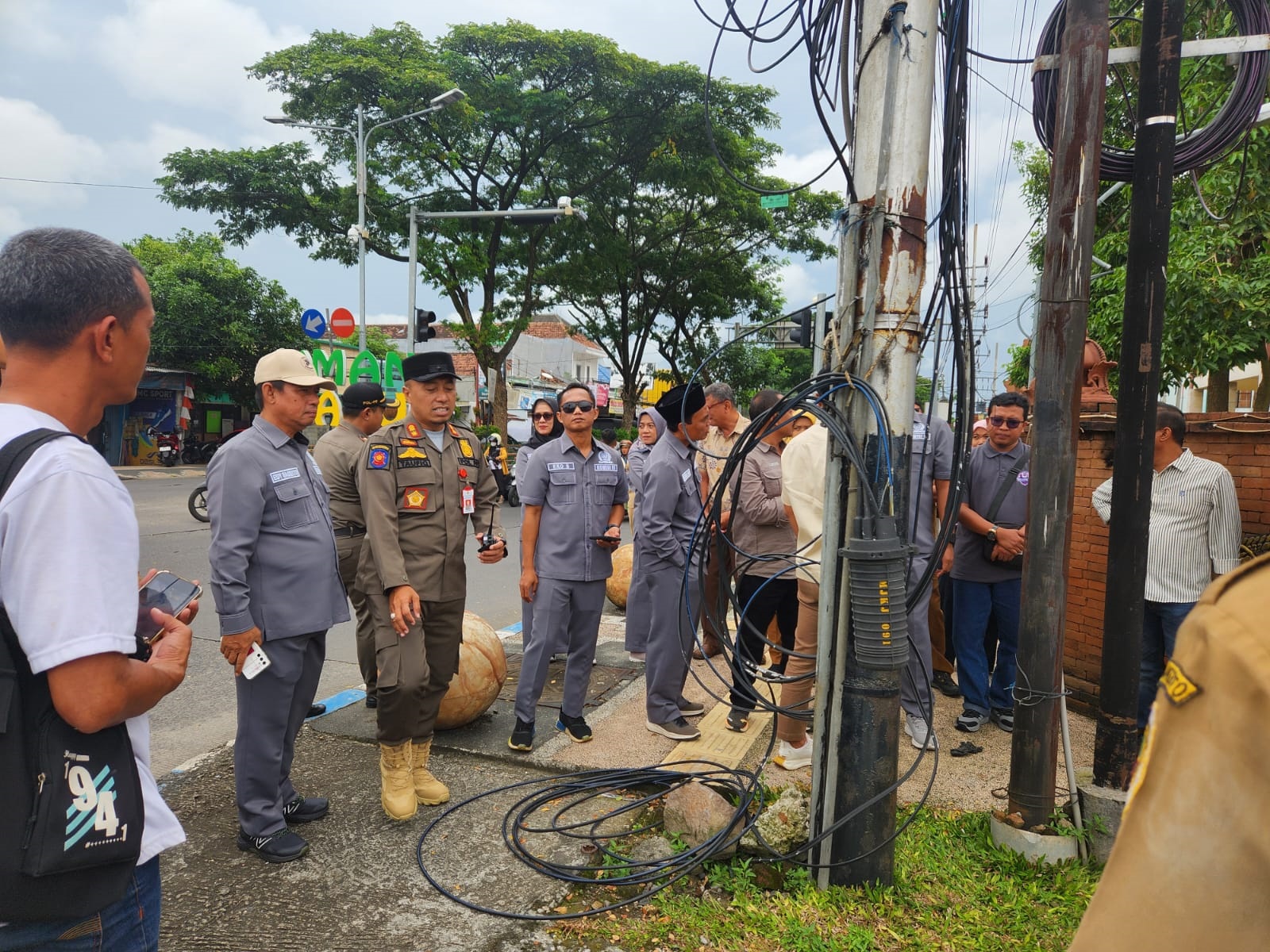 DIATENSI: Kepala Satpol PP Kabupaten Mojokerto M. Taufiqurrahman bersama Komisi III DPRD sidak pendirian tiang dan jaringan kabel FO ilegal di simpang empat Jalan RA Basuni, Desa/Kecamatan Sooko.