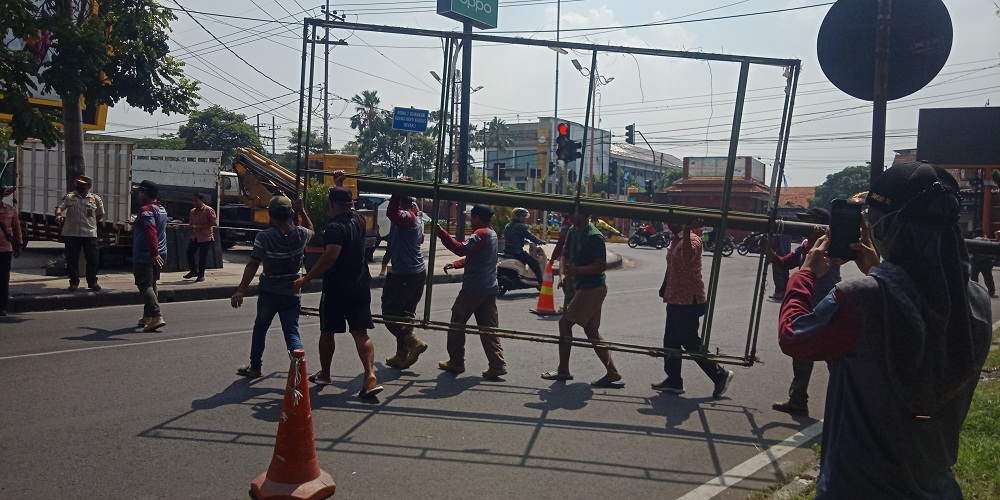 TEGAS: Satpol PP Kabupaten Mojokerto menertibkan tiang baliho yang tidak mengantongi izin atau tidak membayar pajak daerah.