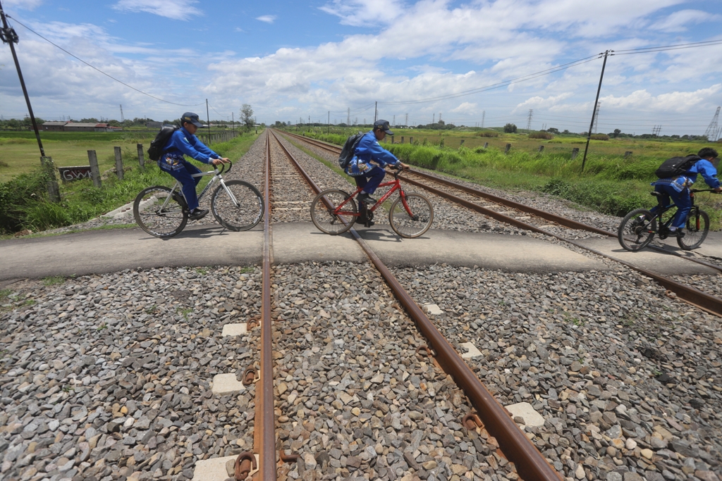 EKSTRA WASPADA: Seorang pengendara berhenti di perlintasan kereta api tanpa palang pintu di Dusun Wonoayu, Desa Kepuhanyar, Kecamatan Mojoanyar, saat kereta api melintas, kemarin (5/3).
