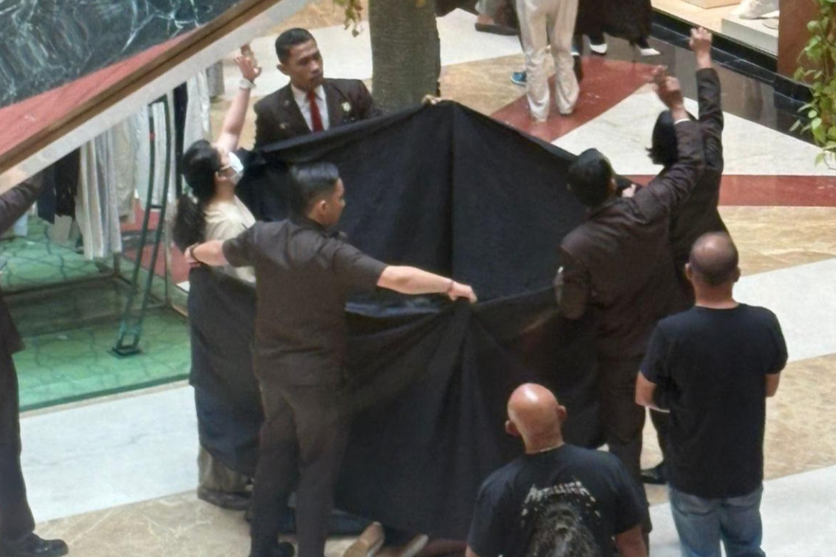 Petugas keamanan menutup area di dalam Pondok Indah Mall 2 dengan kain hitam setelah seorang pria tewas usai diduga melompat dari lantai tiga pada Minggu (8/3).