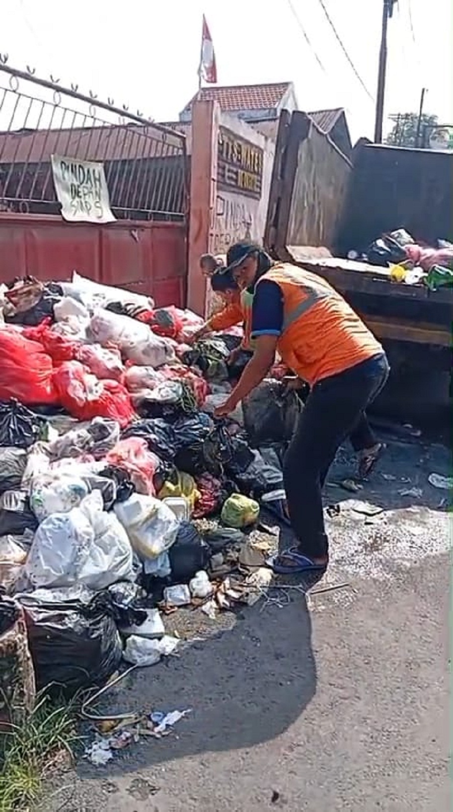 DIANGKUT: Petugas DLH Kota Mojokerto membersihkan sampah yang dibuang di depan TPS Wates, Kelurahan Wates, Kecamatan Magersari, Kota Mojokerto, kemarin (9/3).  
