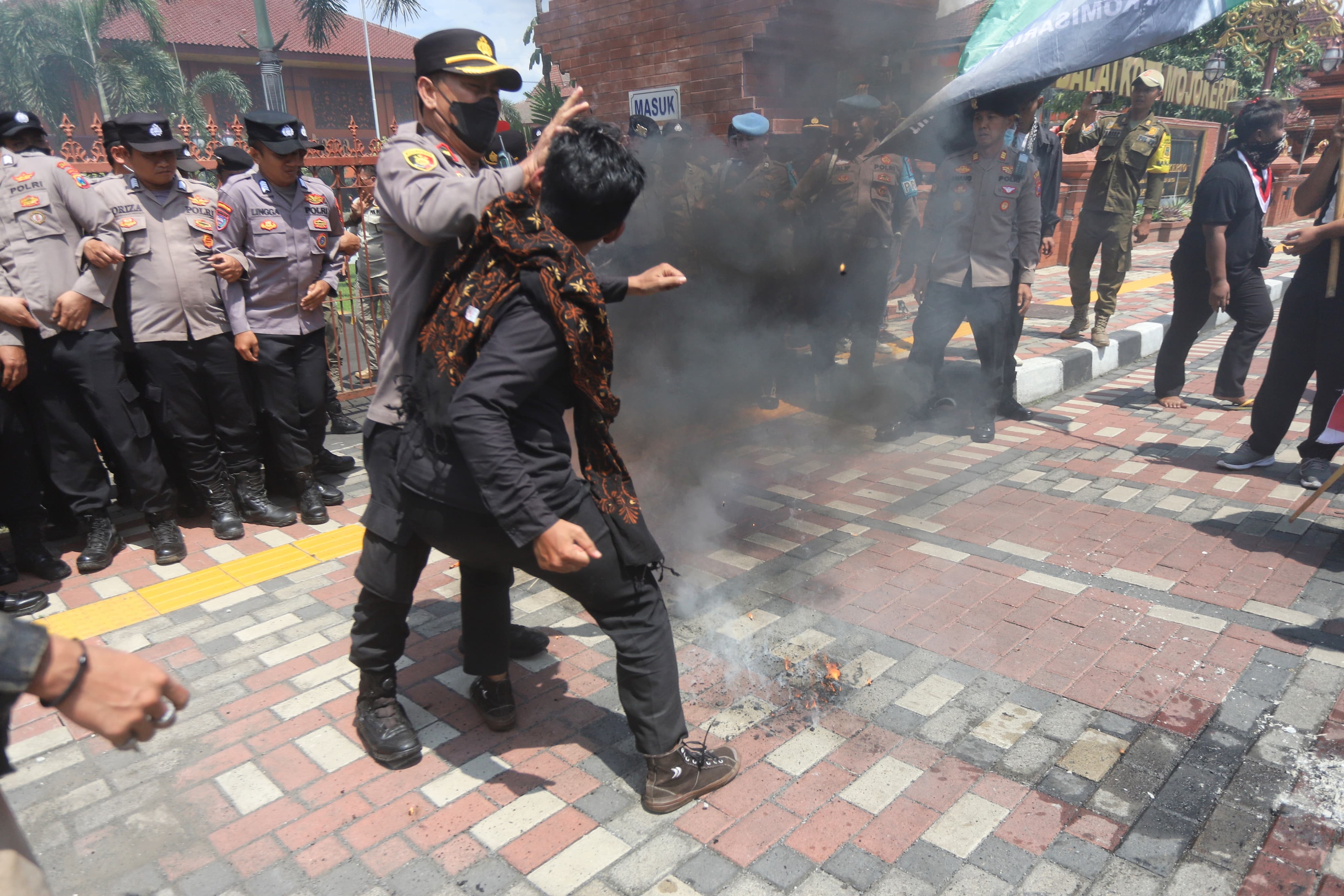 MEMANAS: Seorang demonstran bersitegang dengan anggota polisi saat aksi di balai kota 