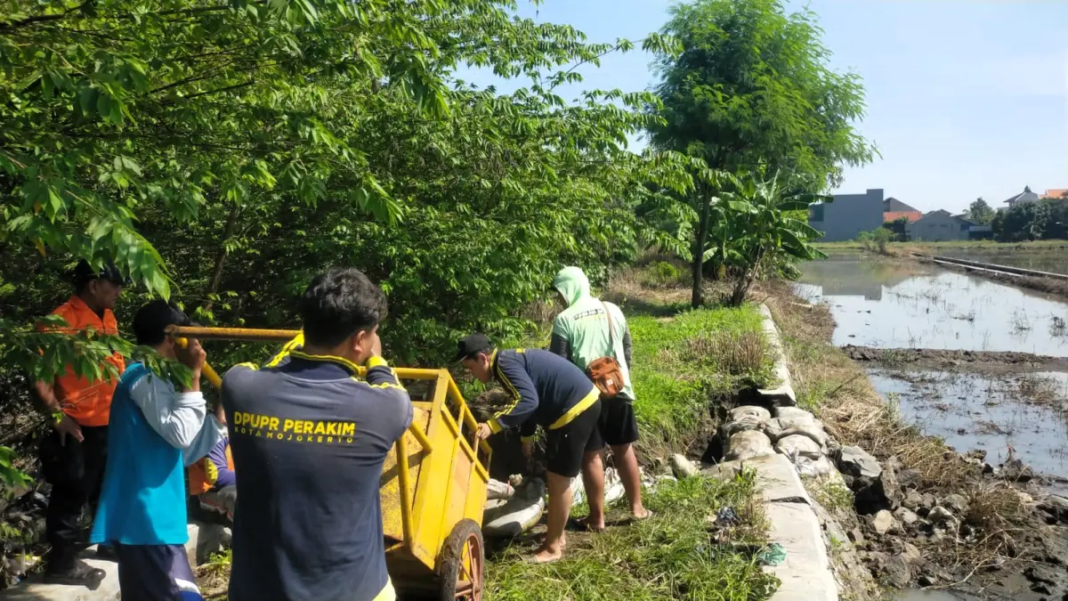 DIPERBAIKI: Tanggul Sungai Ngumpak di Kelurahan Meri, Kelurahan Kranggan, yang jebol ditangani dengan penanggulan darurat, kemarin (17/3). (Martda Radar Mojokerto)