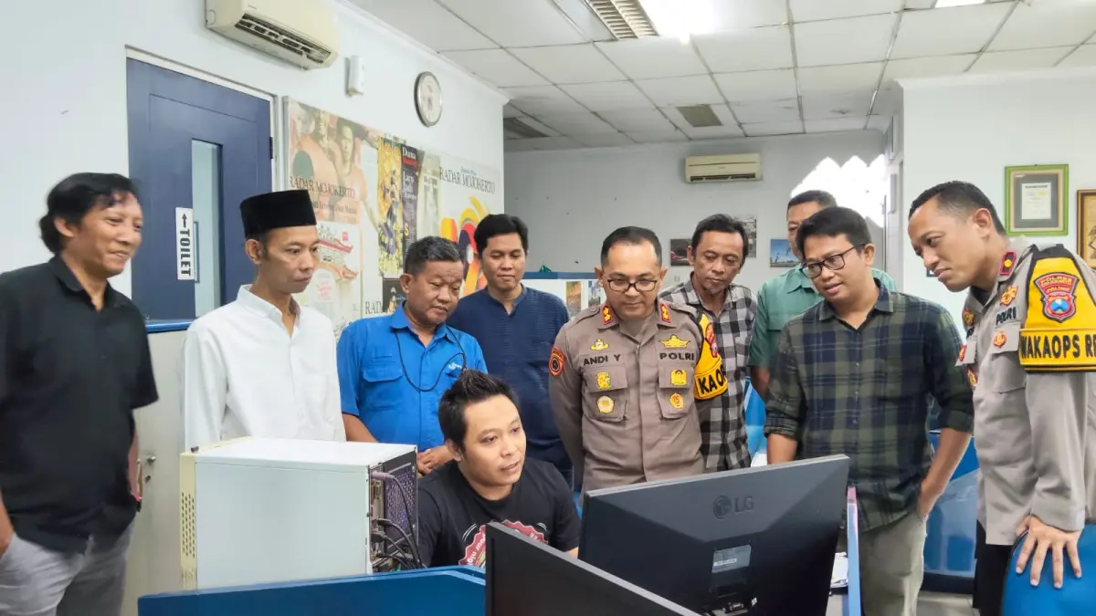 SANTAI DAN AKRAB: Kapolres Mojokerto AKBP Andi Yudha Pranata dan Wakapolres Mojokerto Kompol Ris Andrian Yudo Nugroho mengamati proses produksi media cetak di dapur redaksi bersama kru Jawa Pos Radar Mojokerto, Kamis (26/3) sore. (Oce JPRM)