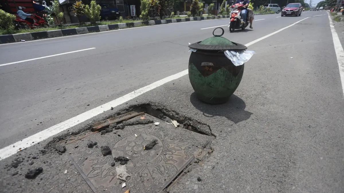 RUSAK: Besi penutup got di Jalan Empunala, Kota Mojokerto, dipasangi pembatas tong sampah karena jebol, kemarin (30/3). (Sofan JPRM)

&nbsp;