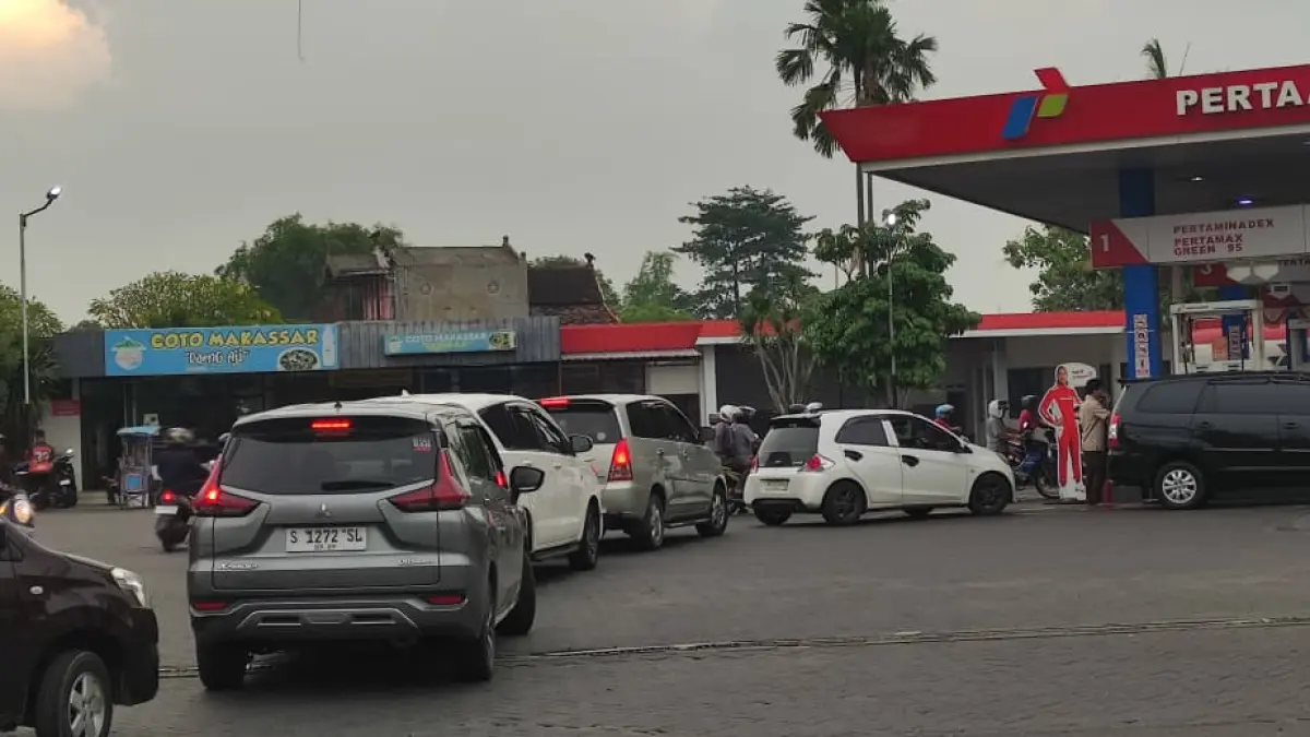 DIDOMINASI MOBIL PRIBADI: Antrean kendaraan menunggu giliran pengisian BBM tampak mengular di SPBU Jalan RA Basuni, Desa/Kecamatan Sooko, kemarin (31/3). Kondisi ini dipicu terkait kabar kenaikan harga BBM oleh pemerintah. (Arief JPRM)