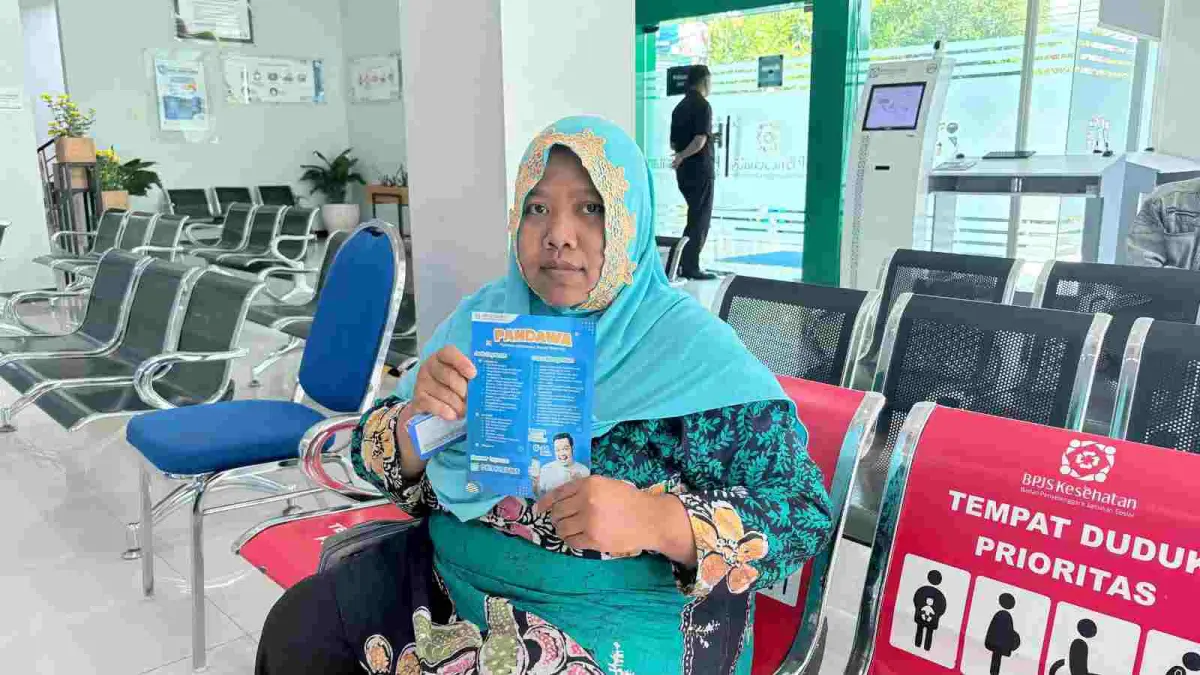 Lailatin Khusul Saidah (32), atau yang akrab disapa Laila, warga Dusun Kangkungan, Kecamatan Gedeg,  menunjukkan brosur layanan Pandawa JKN. 