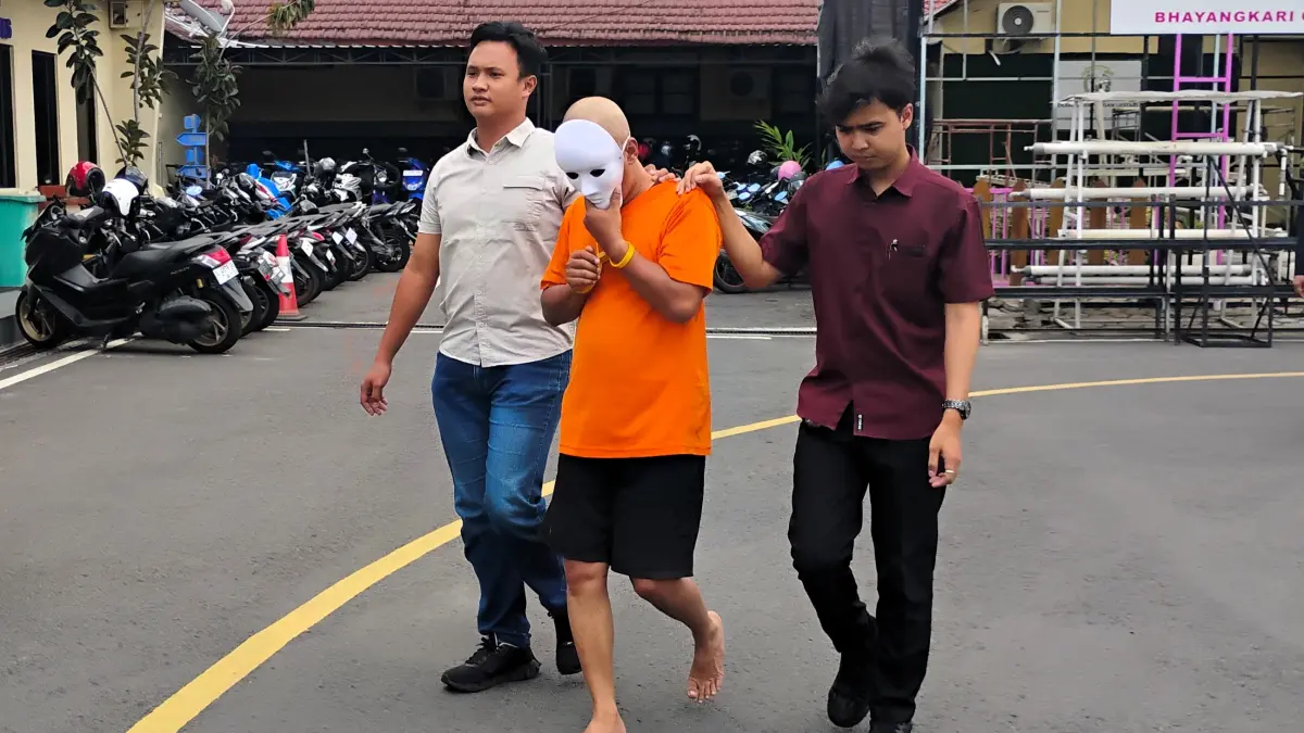 TAK BERMORAL: Tersangka saat digelandang petugas ke ruang tahanan Polres Mojokerto Kota. (Martda JPRM)