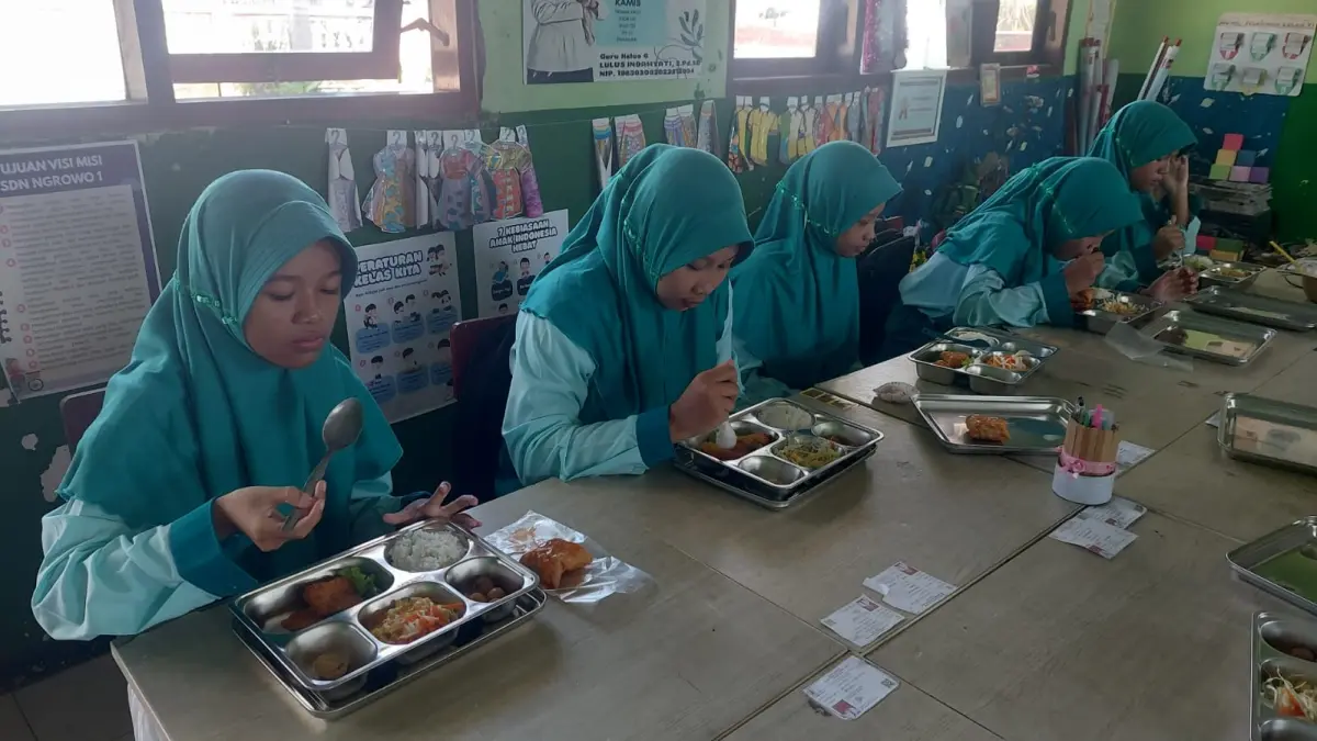 BERTAHAP: Sejumlah siswa SDN Ngrowo 1, Kecamatan Bangsal menyantap menu MBG yang didistribusikan, kemarin (1/4). (Oce JPRM
)