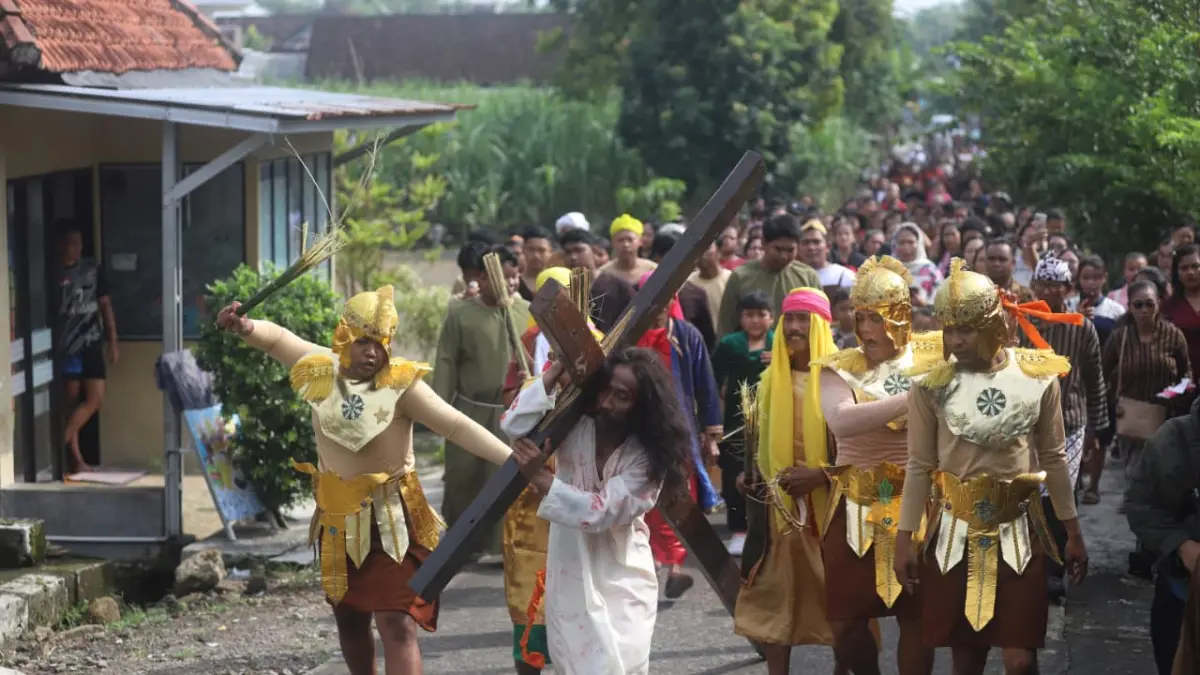 JALAN SALIB DAWARBLANDONG: Para pemuda gereja menyuguhkan drama kolosal yang memvisualisasikan kisah penderitaan Yesus Kristus saat memanggul kayu salib menuju Bukit Golgota di Desa Banyulegi, Kecamatan Dawarblandong, Kabupaten Mojokerto, Jumat (3/4). (Sofan JPRM)
