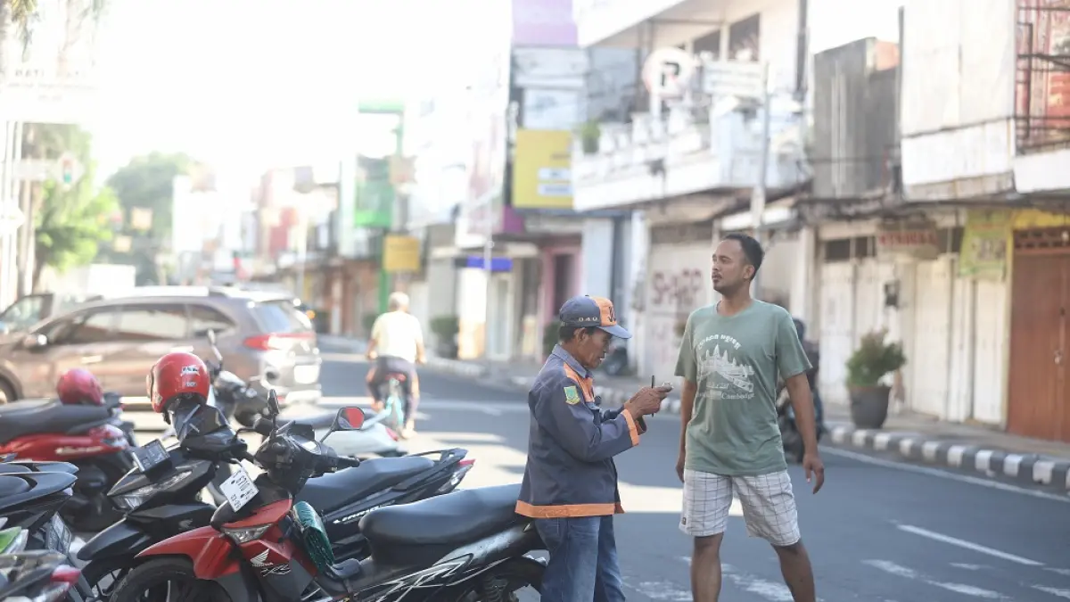 DIKELUHKAN WARGA: Aktivitas juru parkir di area parkir berlangganan di Jalan Mojopahit, Kota Mojokerto.