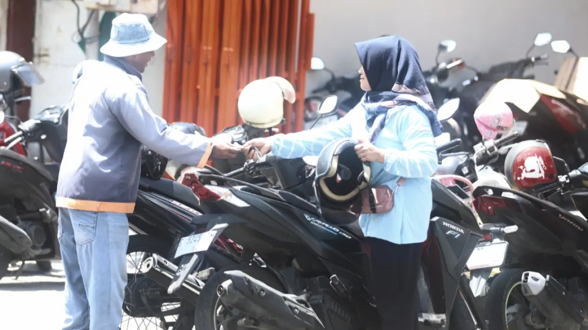 DIKELUHKAN: Warga membayar biaya parkir kepada juru parkir di area parkir berlangganan di Jalan Mojopahit, Kota Mojokerto, kemarin (5/4). (Ok-ris/Foto// sofan)