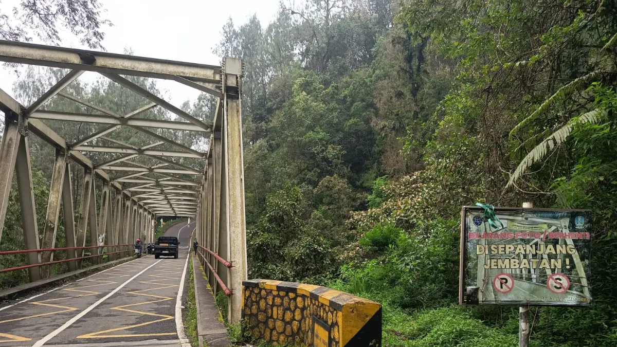 MEMBANDEL: Pengendara berhenti di atas jembatan Pacet-Cangar yang menghubungkan Kabupaten Mojokerto dan Kota Batu. Ok-ris


