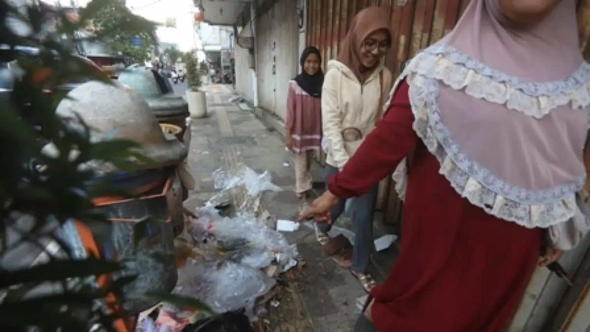 KUMUH: Sejumlah pejalan kaki tampak menghindari tumpukan sampah yang meluber di trotoar Jalan Mojopahit, Kota Mojokerto, Selasa (7/4). (Sofan JPRM)