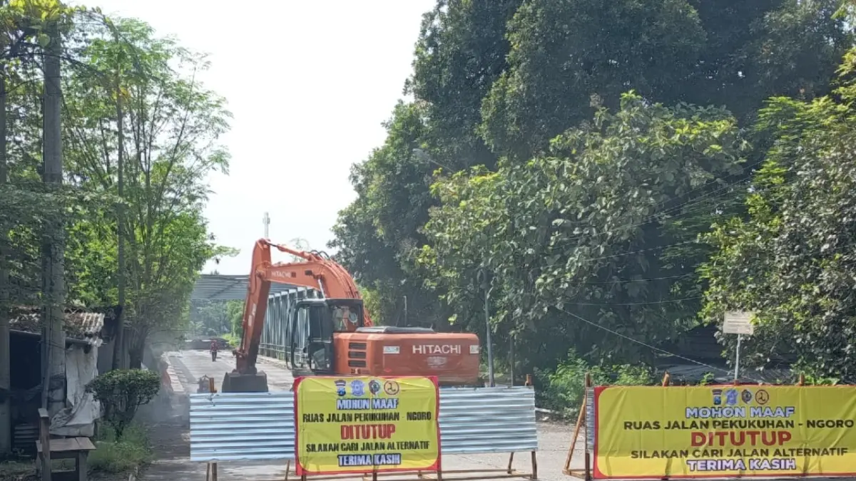 DIALIHKAN: Jalan rusak di ruas Pekukuhan-Ngoro, Kabupaten Mojokerto, dilakukan rekonstruksi menggunakan alat berat kemarin. (Rizal JPRM)