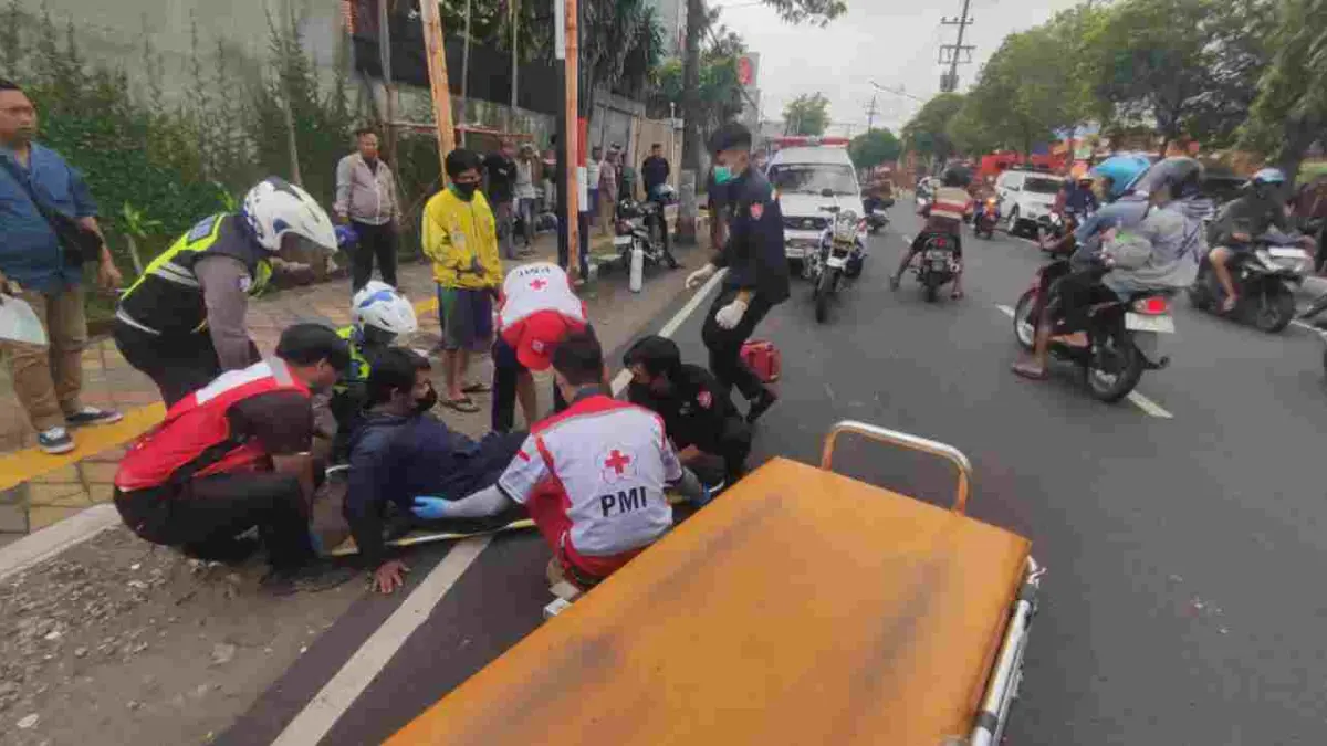 LAKA: Petugas tengah memberikan perawatan sementara terhadap pengendara motor yang terlibat kecelakaan di Jalan Bhayangkara, Kota Mojokerto, Kamis (9/4). (Arief JPRM)