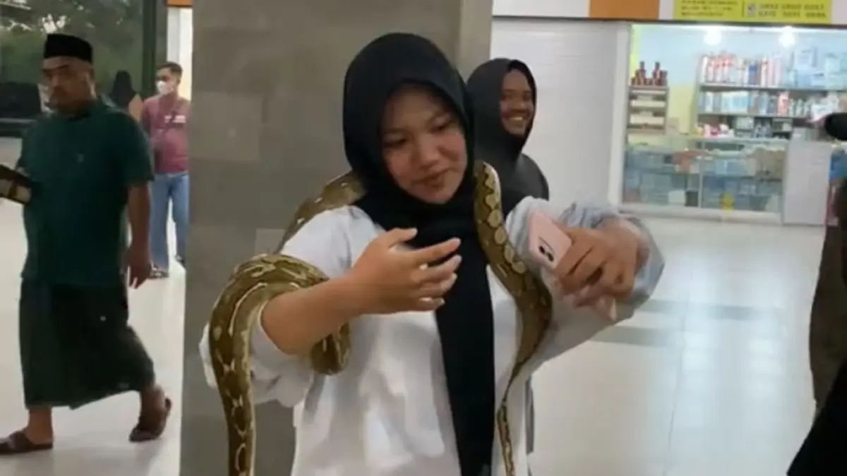 PAMERAN REPTIL:&nbsp;Salah satu pengunjung berswafoto dengan ular dalam acara gathering terakhir beberapa bulan lalu di Pasar Semeru Kota Mojokerto. 
