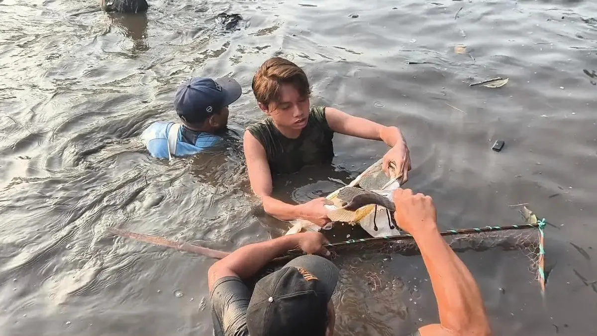 BERBURU IKAN: Warga memburu ikan di mata air Sumber Dhuwur, Desa Wonosari, Kecamatan Ngoro, Kabupaten Mojokerto, Minggu (12/4) dalam tradisi bedah sumber. (Rizal JPRM)