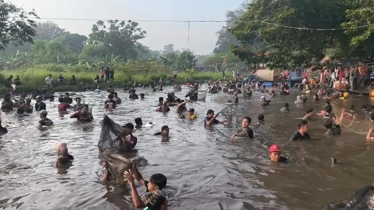 BERBURU IKAN: Warga memburu ikan di mata air Sumber Dhuwur, Desa Wonosari, Kecamatan Ngoro, Kabupaten Mojokerto, Minggu (12/4) dalam tradisi bedah sumber. (Rizal JPRM)
