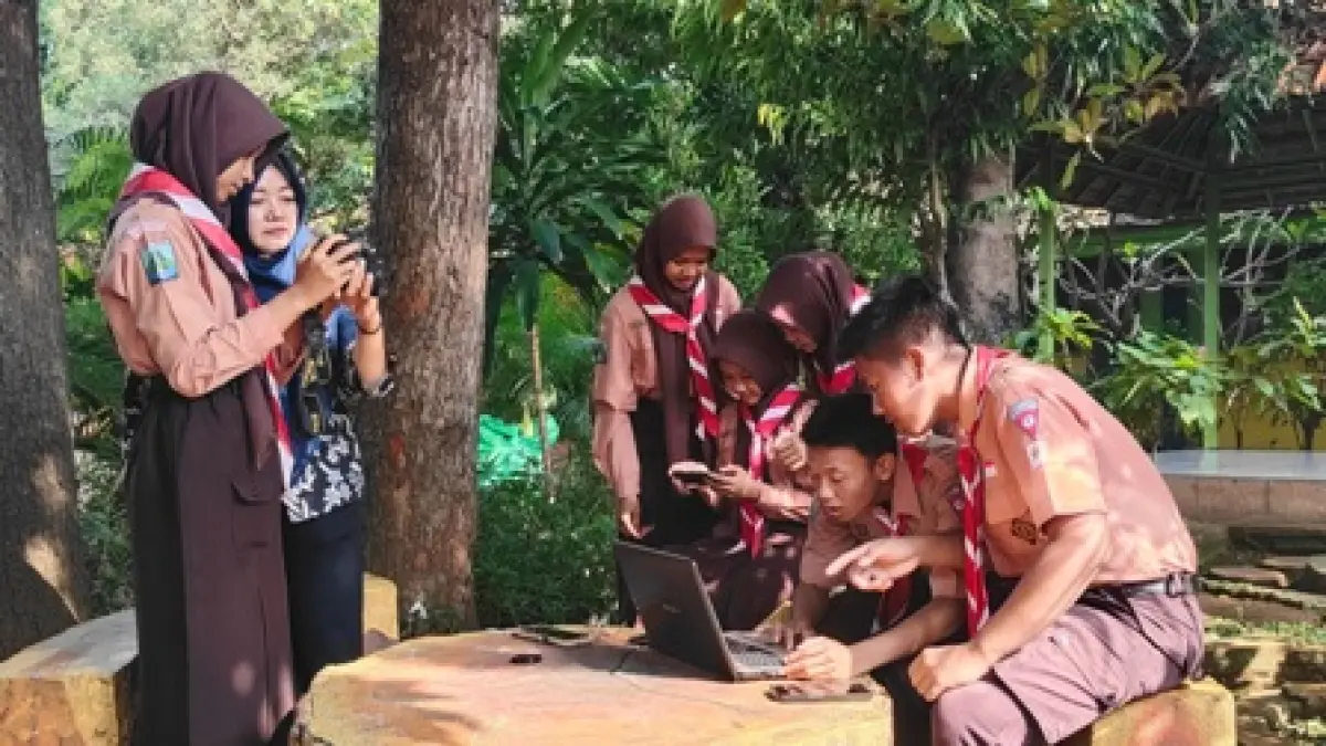PEMANFAATAN DIGITAL: Seorang guru mendampingi siswa saat menggunakan gawai dalam kegiatan pembelajaran siswa di SMPN 1 Sooko. Dispendik Kabupaten Mojokerto akan menerapkan pembatasan penggunaan smartphone bagi siswa di lingkungan sekolah. (Oce JPRM)