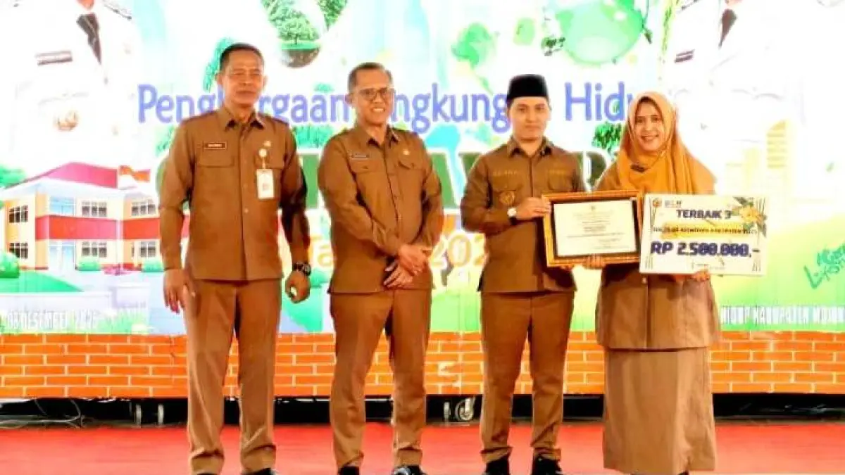ISTIMEWA: Kepala SMPN 2 Ngoro Satsuana Jatiningtyas saat menerima penghargaan sekolah Adiwiyata tingkat Kabupaten oleh Bupati Mojokerto Muhammad Albarraa. (Oce JPRM)