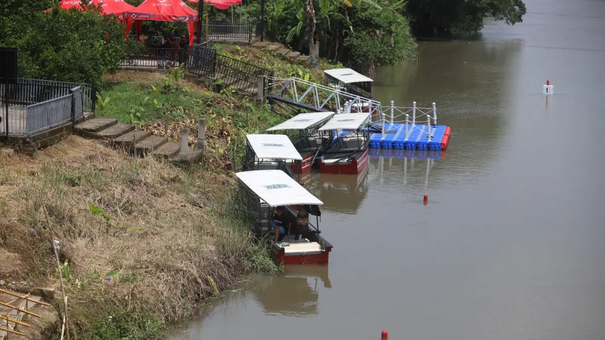 Sejumlah warga menonton kejuaraan dayung tingkat Jawa Timur dari atas Jembatan Rejoto yang melintang di atas Sungai Ngotok, kompleks TBM, Kecamatan Prajurit Kulon, Kota Mojokerto, Minggu (19/4). Sebagian warga sempat menyoroti kondisi perahu susur sungai dan harga tiket sebesar Rp 20 ribu. 